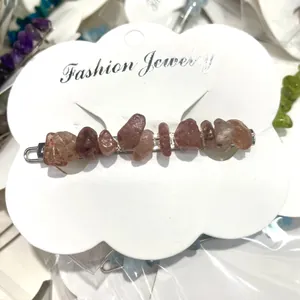 Detailed view of an irregular natural crystal stone hair clip on a white display card.