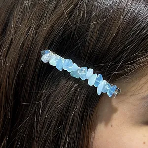 Macro detail of irregular blue natural crystal crushed stone hair clip on dark straight hair