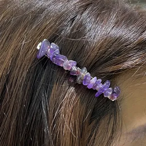 Detailed view of irregular purple crystal stone hair clip on dark hair profile