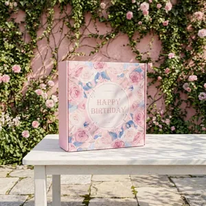 Élégante boîte cadeau florale rose avec texte Happy Birthday dans un jardin ensoleillé