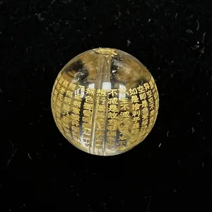 Macro detallada de una cuenta de cristal de cuarzo ahumado con escrituras budistas