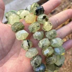 Macro view of faceted natural green crystal beads showing unique black needle inclusions