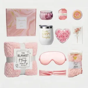 Elegante set regalo rosa da donna con coperta, candela, bicchiere e prodotti spa