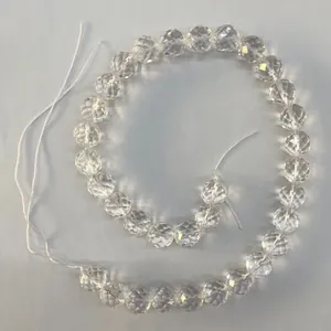 Vue détaillée de perles rondes en cristal de roche brésilien de haute qualité à 64 facettes.