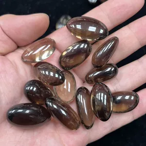 Detalle de cabujones naturales de cuarzo ahumado pulido en varias formas ovales lisas