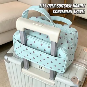 Trousse à maquillage vert menthe à pois fixée sur une valise pour voyager facilement.