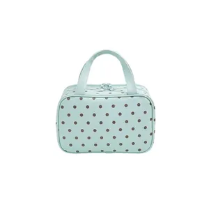 Trousse de maquillage vert menthe à pois avec poignées et zip sur fond blanc pur