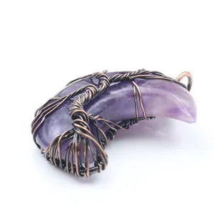 Detailed view of a wire-wrapped tree of life on a purple crescent moon gemstone pendant.