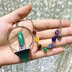 Detail of a seven chakra stone pendant featuring a green hexagonal crystal pillar.