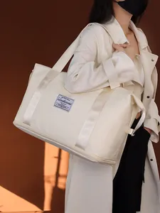 Große cremeweiße wasserdichte Reisetasche, getragen von einem Model für den Sport