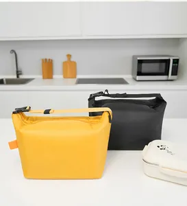 Modern kitchen scene featuring two portable insulated lunch bags in yellow and black