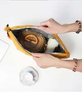 Detail view of a yellow insulated lunch bag with thickened aluminum foil lining.
