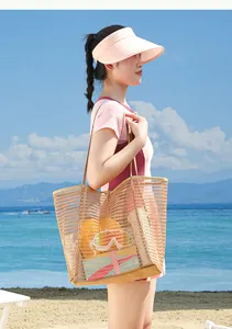 Femme asiatique sur la plage portant un grand sac de plage en maille pour le voyage