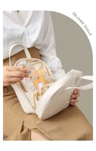 Close-up of white PU cosmetic bag held by a woman, showing skincare products inside