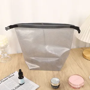 Bolsa impermeable gris para ropa en un escritorio con accesorios de estilo de vida