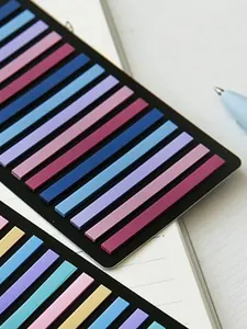 Detailed macro view of colorful narrow index tabs on a notebook surface