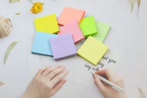 Blocs de notas adhesivas color macaron 76x76mm en un escritorio con manos escribiendo
