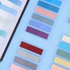 Vista dettagliata di varie linguette indice in PET trasparente Morandi colorate su foglio blu
