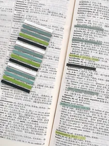 Detailed macro view of colorful transparent writable index tabs applied on book pages