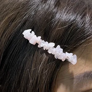 Close-up detail of a hair clip featuring irregular natural pink crystal stones