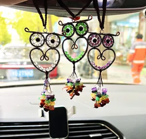 Close-up of three handcrafted owl car hanging ornaments with colorful crystal beads.