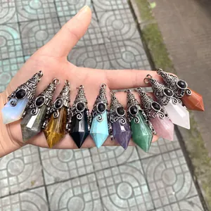 Hand showing diverse hexagonal crystal cone pendants with ornate vintage silver caps.