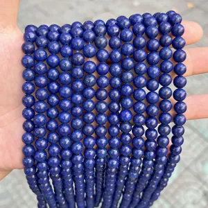 Macro view of multiple strands of natural blue stone round beads held in hand.