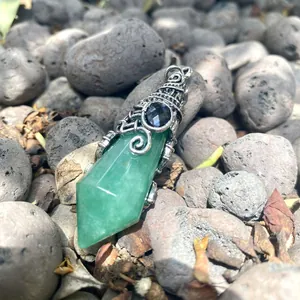 Close-up of a green crystal hexagonal cone pendant with vintage silver metal wrap.