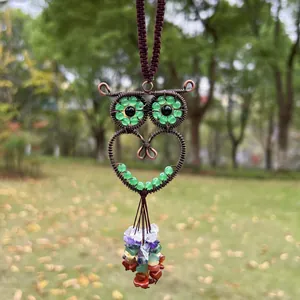 Close-up detail of a handmade owl pendant with colorful crystal beads and copper wire wrap.