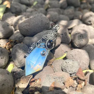 Close-up of a 12-facet hexagonal opal pyramid pendant with gothic bat wing metal wrap