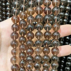Close-up of natural dark round stone beads with a glossy finish for DIY jewelry making.