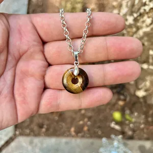 Polished natural tiger eye stone donut pendant necklace detail showing stone texture