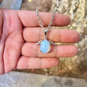 Angel wing opal teardrop pendant necklace with silver chain shown in a detailed hand view