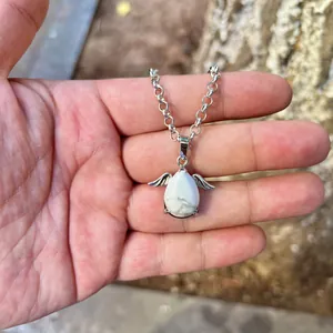 Detailed view of teardrop-shaped white natural stone pendant with silver angel wings.