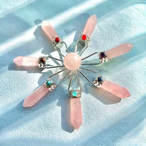 Radial arrangement of rose quartz hexagonal prism pendants with colorful chakra stones.