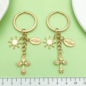 Detail view of golden vintage metal alloy keychain with sun and cross charms on ruler