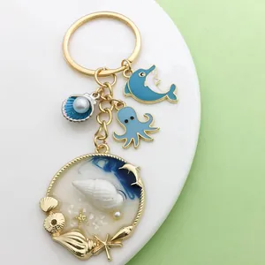 Detalle de llavero con tema océano azul con dijes de delfín pulpo y caracola
