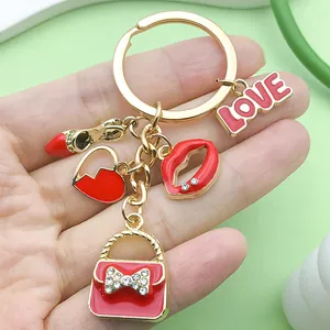 Primer plano de dijes de esmalte rojo que incluyen corazón y labios en un llavero dorado