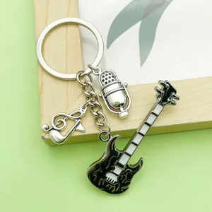 Close-up of music-themed keychain featuring guitar, microphone, and musical note charms