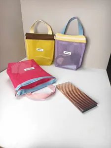 A set of vibrant color-block mesh makeup bags with Storage bag labels on a white desk