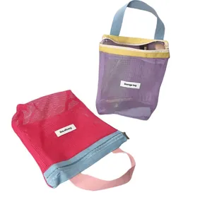 Close-up view of two mesh cosmetic storage bags in vibrant purple and pink contrast colors