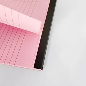 Detalle de bloc de notas rosa A5 con líneas y páginas microperforadas para arrancar