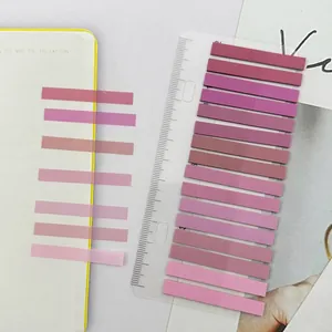 Macro view of translucent gradient pink PET index tabs attached to a clear plastic ruler