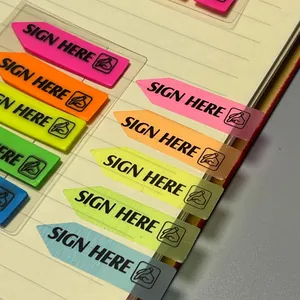 Détail macro d'onglets d'index PET fluorescents avec texte SIGN HERE sur page de carnet