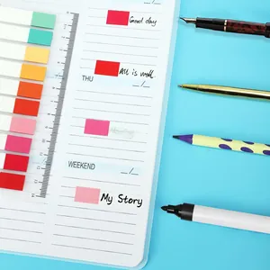 Detailed macro view showing colorful translucent index tabs applied on a white planner page.