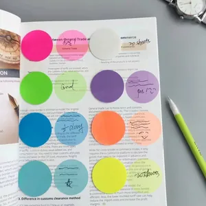 Gros plan de notes autocollantes rondes transparentes en 8 couleurs sur un livre