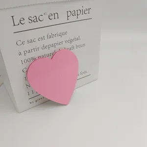 Gros plan d'un pense-bête en PET rose en forme de cœur sur un sac décoratif en papier blanc
