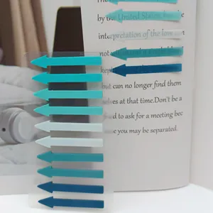 Close-up of Morandi colored arrow index tabs used on a book page for reading and marking.