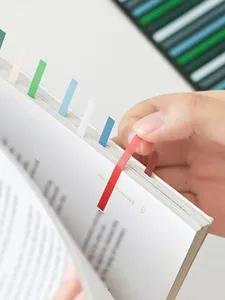 Close-up of colorful slim transparent index tabs being used in a notebook for marking.