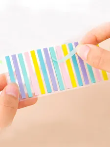 Close-up of peeling a colorful transparent index tab from its plastic backing sheet